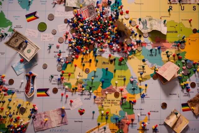 Global trade map with pins, currencies, and travel markers representing international business, translation services, and cross-border communication