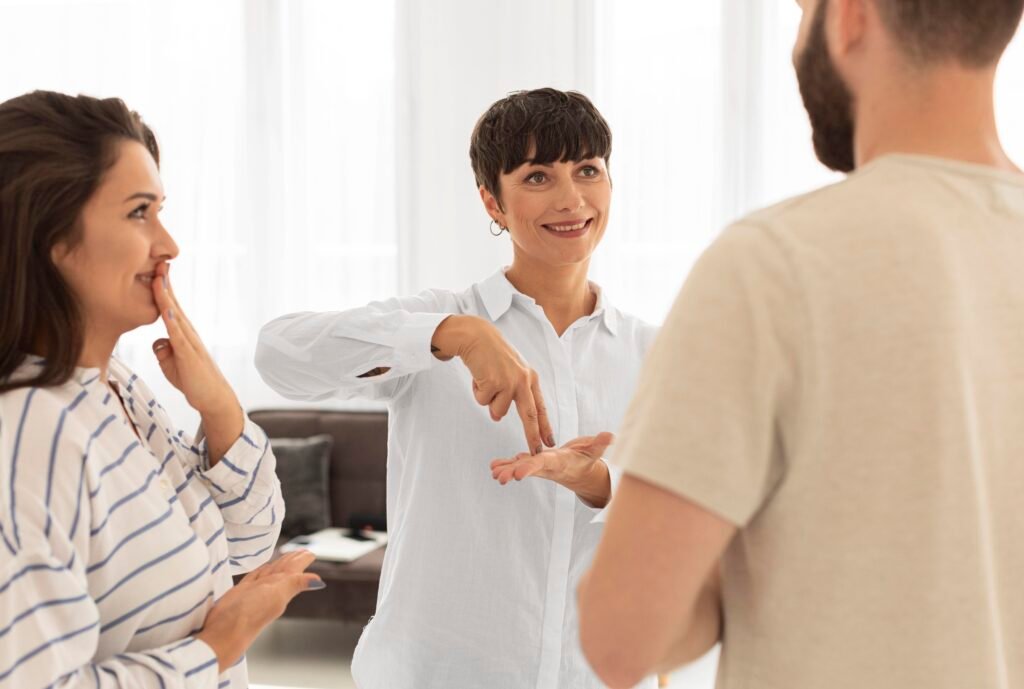 ASL interpreter facilitating communication between Deaf and hearing participants during an in-person interpreting session.