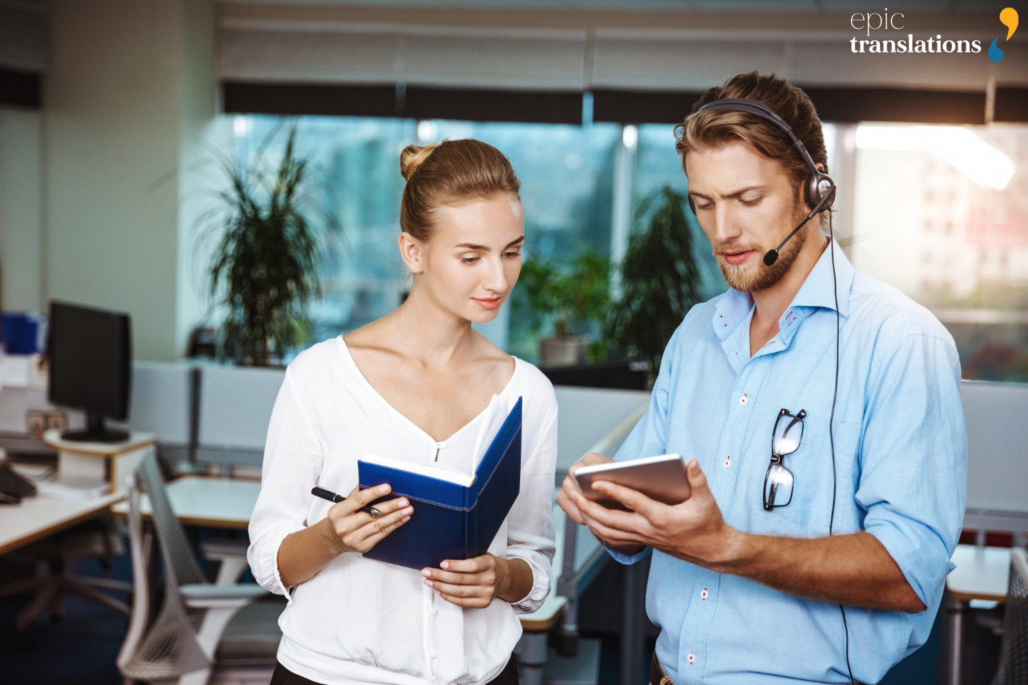 Professional interpreter using a headset to facilitate an over-the-phone interpreting session between colleagues in an office setting